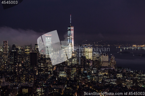 Image of New York City skyline with lower Manhattan skyscrapers in storm at night.