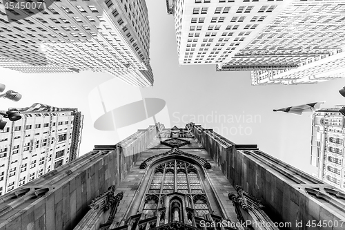 Image of Wide angle upward view of Trinity Church at Broadway and Wall Street with surrounding skyscrapers, Lower Manhattan, New York City, USA