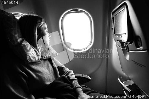 Image of Tired blonde casual caucasian lady sleepin on seat while traveling by airplane. Commercial transportation by planes.