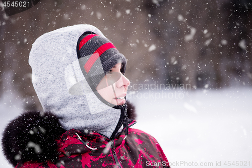 Image of Portrait of young woman on snowy winter day