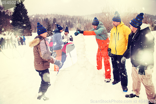 Image of group of young people making a snowman