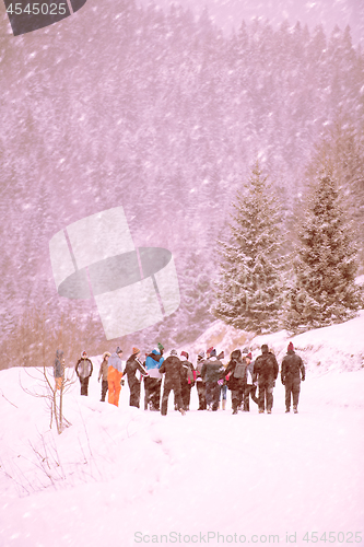 Image of group of young people walking through beautiful winter landscape