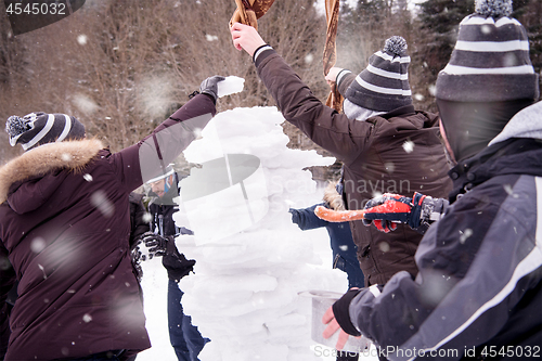 Image of group of young people making a snowman