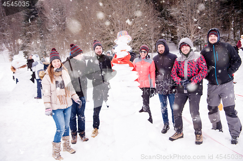 Image of group portait of young people posing with snowman
