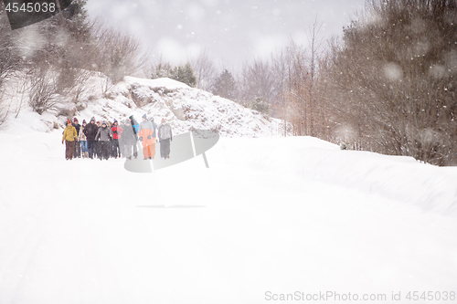 Image of group of young people walking through beautiful winter landscape