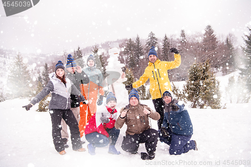 Image of group portait of young people posing with snowman