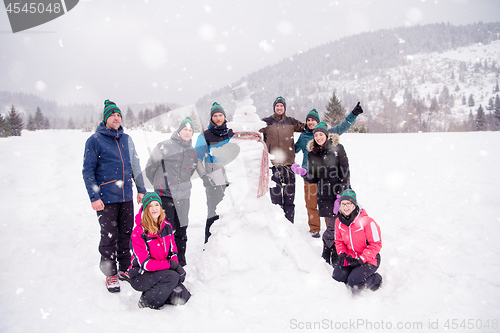 Image of group portait of young people posing with snowman