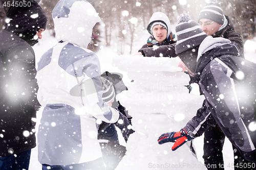 Image of group of young people making a snowman