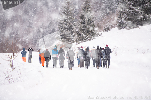 Image of group of young people walking through beautiful winter landscape