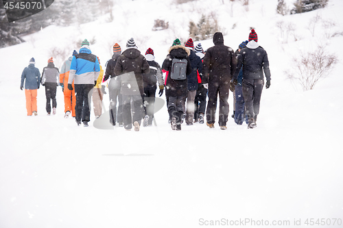 Image of group of young people walking through beautiful winter landscape