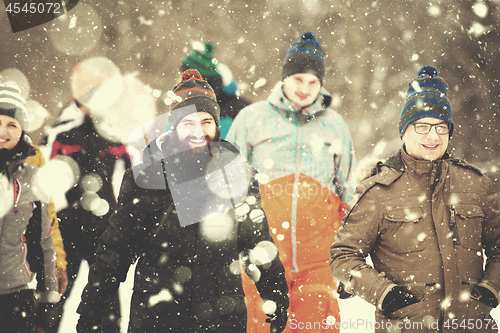 Image of group of young people walking through beautiful winter landscape