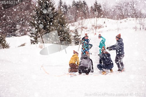 Image of group of young people making a snowman