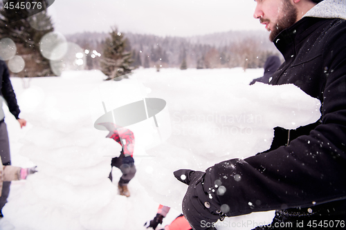 Image of group of young people making a snowman