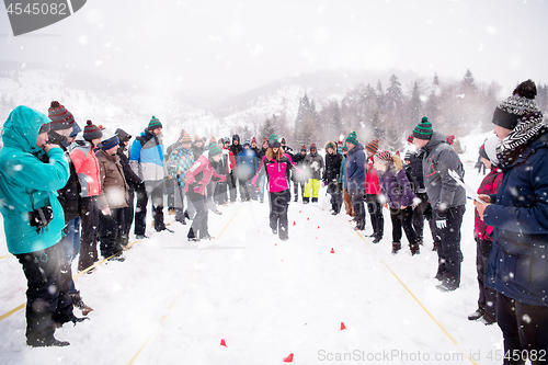 Image of group of young people having blindfolded games competition