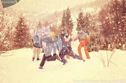 Image of group of young people having fun in beautiful winter landscape