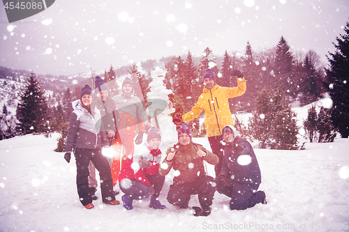 Image of group portait of young people posing with snowman