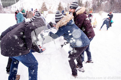 Image of group of young people making a snowman