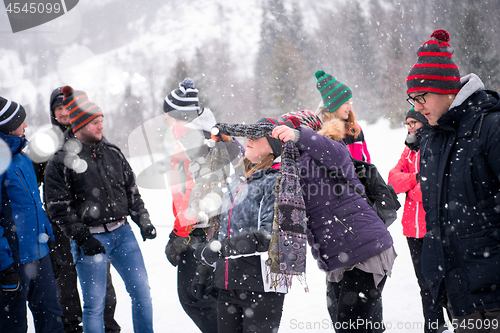 Image of group of young people having blindfolded games competition