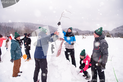 Image of group of young people making a snowman