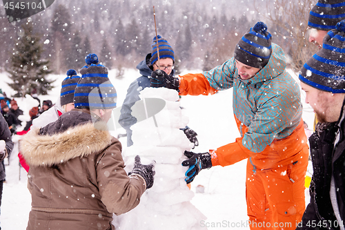 Image of group of young people making a snowman