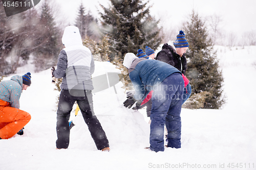 Image of group of young people making a snowman