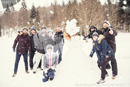 Image of group portait of young people posing with snowman