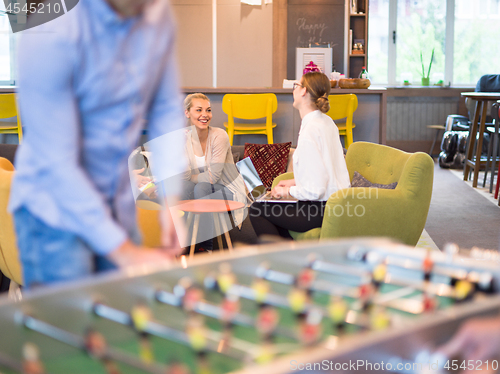 Image of Office People Enjoying Table Soccer Game