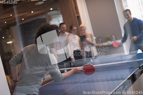 Image of startup business team playing ping pong tennis