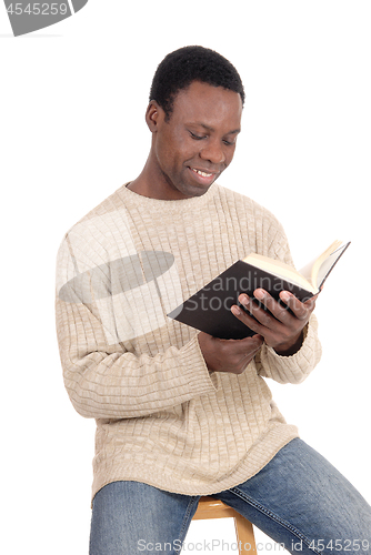 Image of African man sitting and reading his book