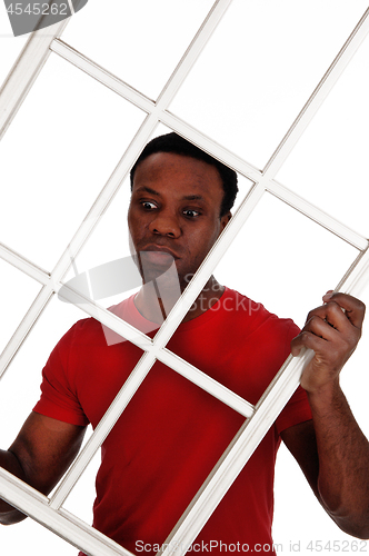 Image of Surprised African man holding up a window frame
