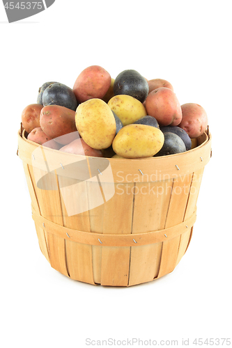 Image of Mini potatoes with different color in wooden basket. 