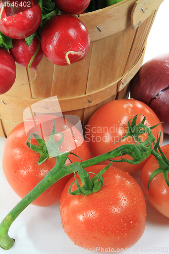 Image of Wooden Bushel and Tomatoes on the vine. 