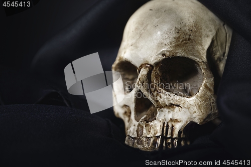 Image of Closeup photo an old skull covered in black robe