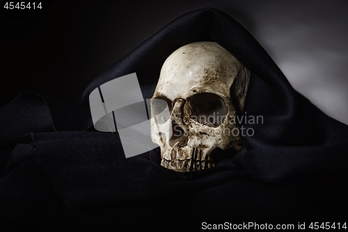 Image of Closeup photo an old skull covered in black robe