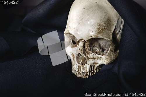 Image of Closeup photo an old skull covered in black robe