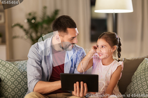 Image of father and daughter listening to music on tablet