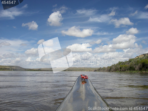 Image of paddling racing kayak on river with desert landscape