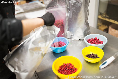 Image of cook pouring berries into bowl at kitchen