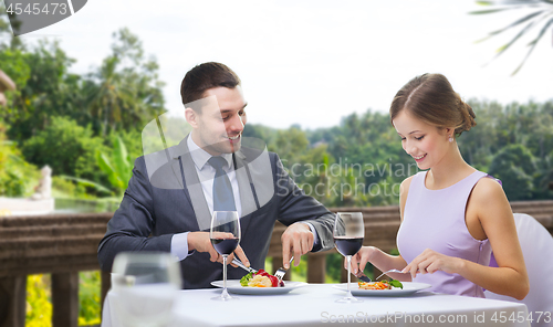 Image of smiling couple eating appetizers at restaurant