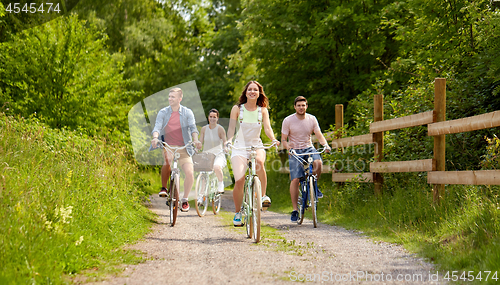 Image of happy friends riding fixed gear bicycles in summer