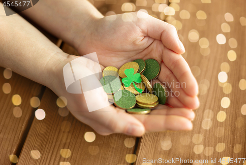 Image of hands with golden coins and shamrock leaf