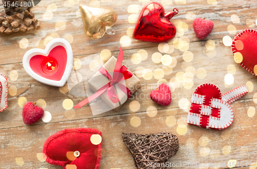 Image of christmas gift, heart shaped decorations, candle