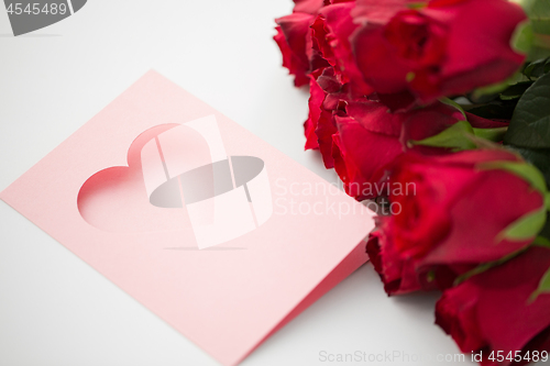 Image of close up of red roses and greeting card with heart