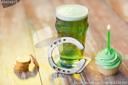 Image of glass of beer, cupcake, horseshoe and gold coins