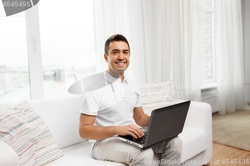 Image of happy man with laptop computer at home