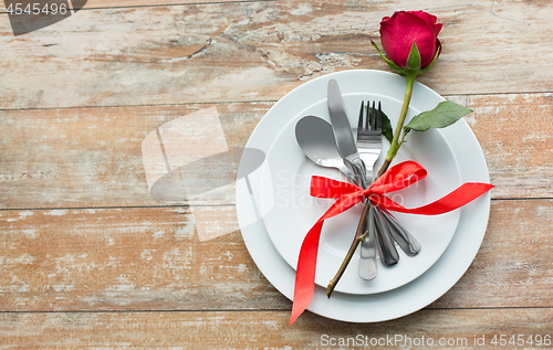 Image of red rose flower on set of dishes