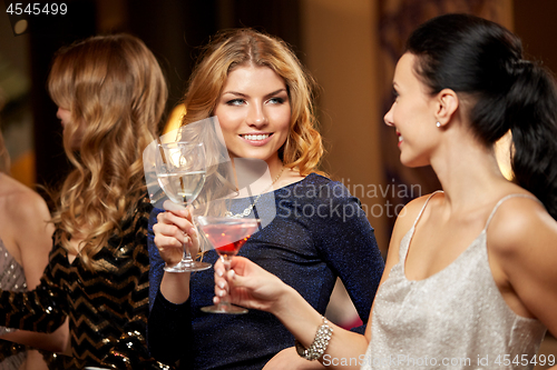 Image of happy women clinking glasses at night club