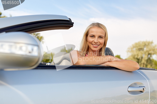 Image of happy young woman in convertible car