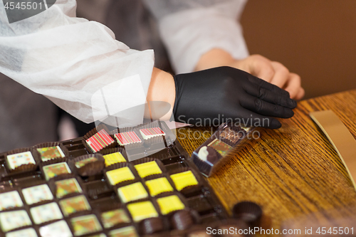 Image of worker packing candies at confectionery shop