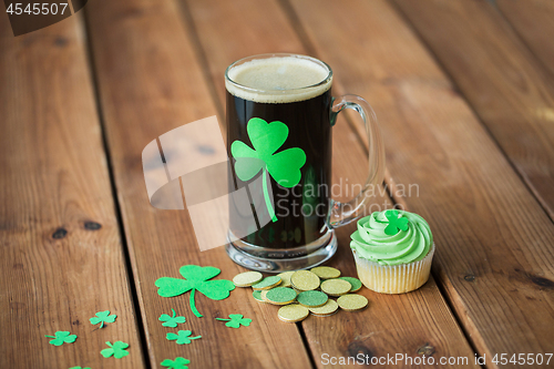 Image of shamrock on glass of beer, green cupcake and coins